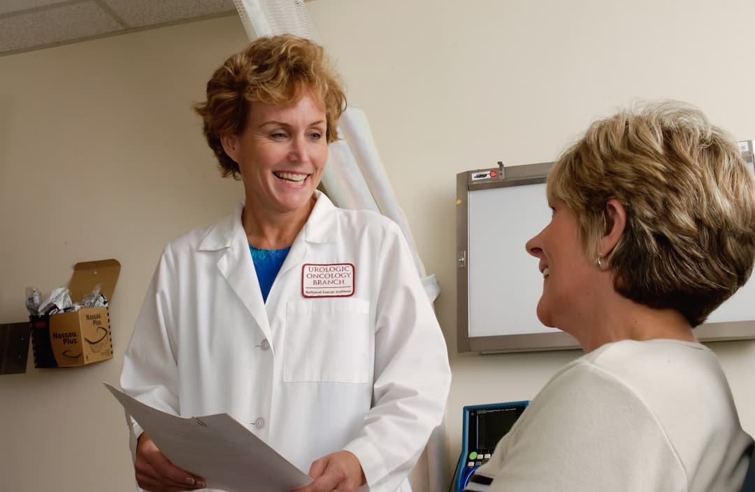 Healthcare professional in white coat reviewing information on a laptop