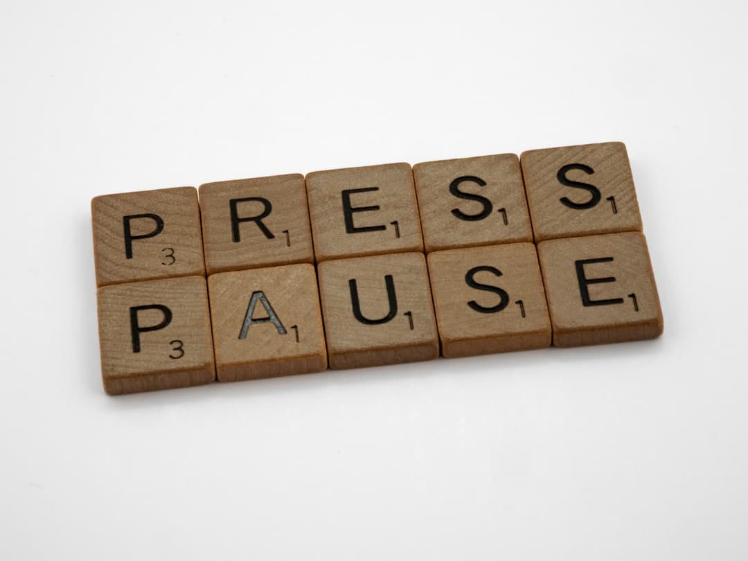Scrabble tiles spelling out the words press pause